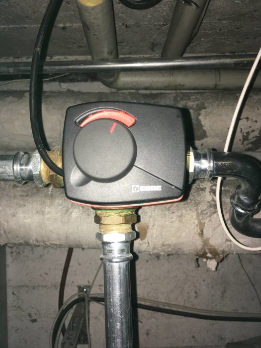 Shunt med vred på rörinstallation mot en grovbetongvägg.