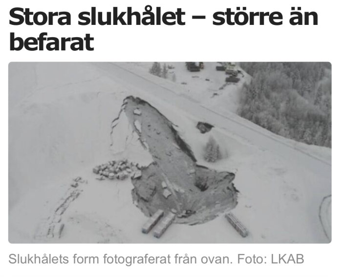 Flygbild på ett stort slukhål i snötäckt landskap som kan liknas vid en symbolisk form.