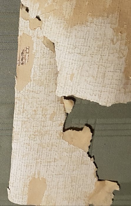 Överlappande tapetlager som skalar av, visar olika färg- och mönsterskikt.