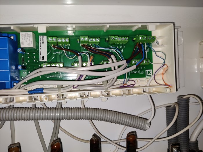 Interiör av ett uppvärmningsskåp med kablarna och zongivare kopplade till en elektronikpanel.