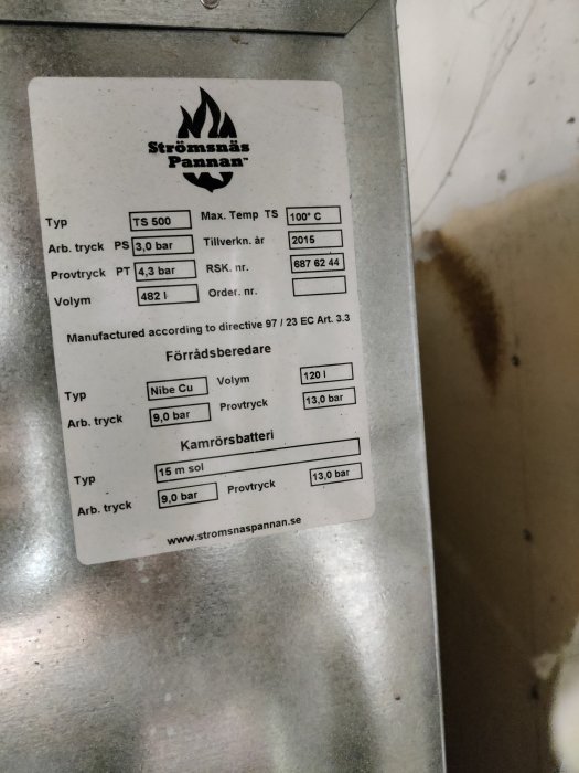 Närbild på skylt på uppvärmningstank med tekniska specifikationer, Strömsnäs Pannan, 482 liter.