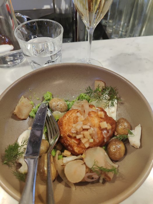 Elegant middagstillbehör för en: stekt fisk med potatis, ärtpuré och champagne.