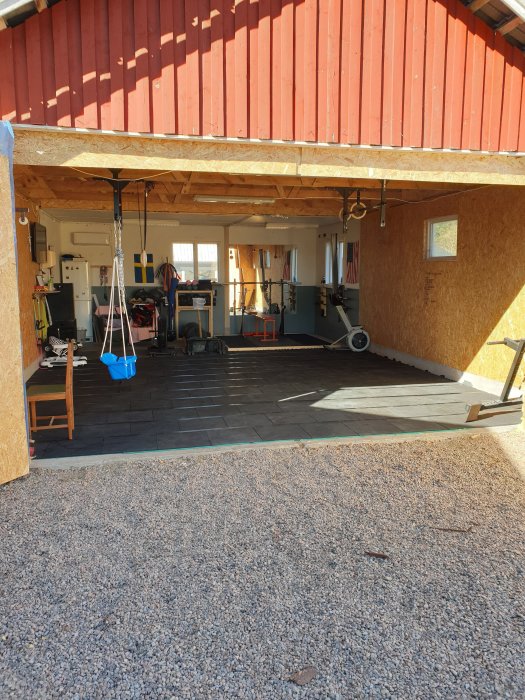 Garage omvandlat till träningslokal med öppen takhöjd och träningsutrustning.