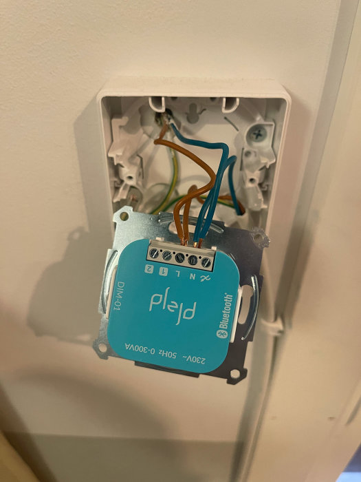Öppen väggströmbrytare med en dimmer-01 enhet och synliga elektriska ledningar.