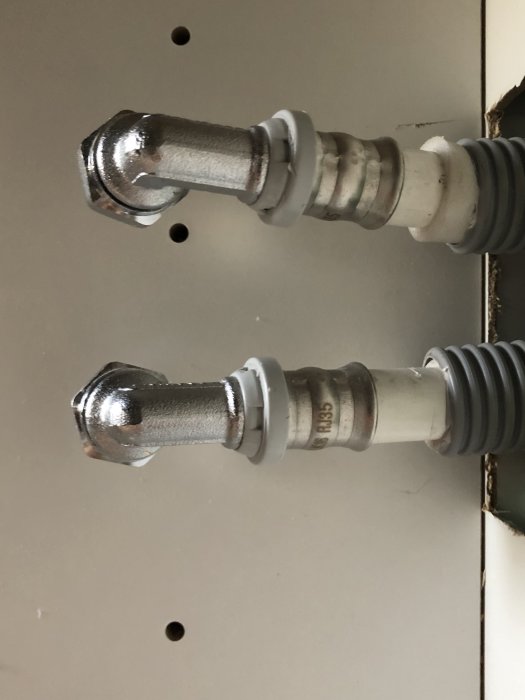 Vattenrör med pluggar utstickande från vägg inför installation av köksblandare.