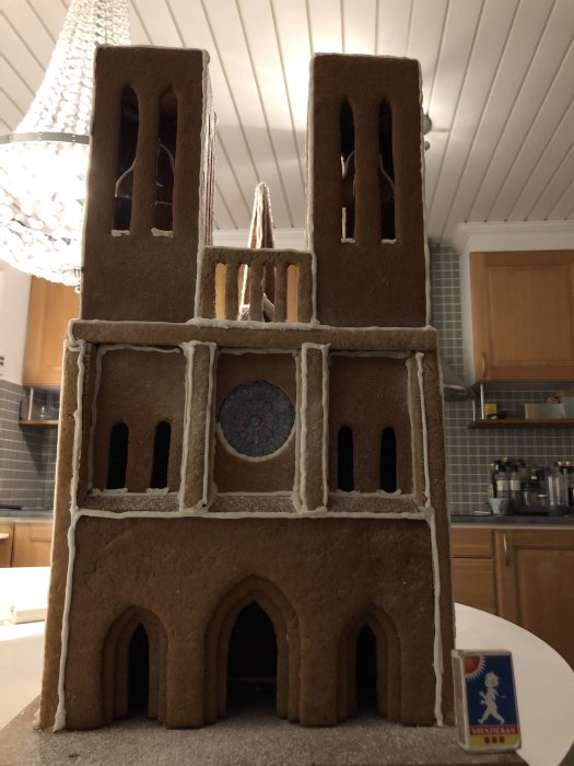 Hemmagjord pepparkaksmodell av Notre Dame-katedralen på ett köksbord.