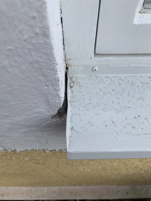 Gapsynlig mellan fönsterbleck och putsad fasad med oregelbunden avstånd och felaktigt veck på blecket.