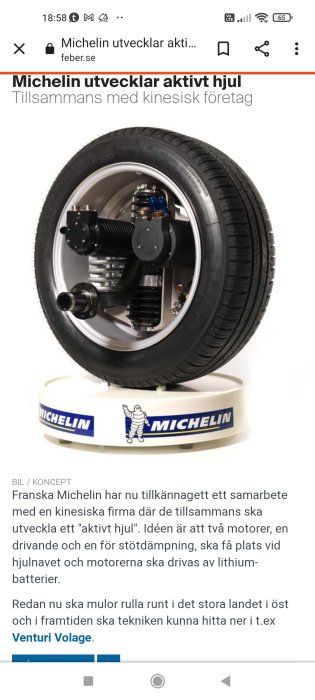 Ett bilhjul med däck från Michelin och integrerade komponenter för drivning och stötdämpning, presenterat på en vit Michelin-piedestal.