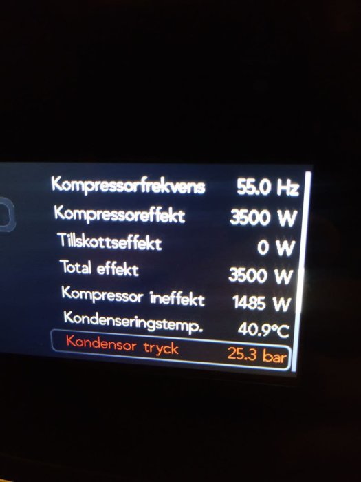 Digital display som visar kompressorfrekvens och effektdata för en värmepump.