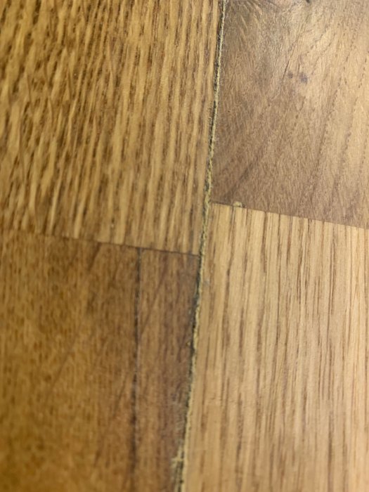 Gummiliknande material som sticker ut från springan i en trä köksbänk.