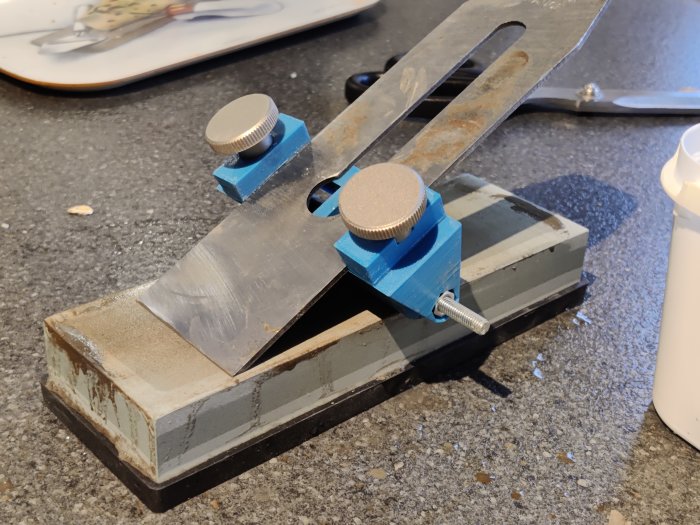 Hantverkskniv och bryne för slipning av verktyg på ett köksbord.