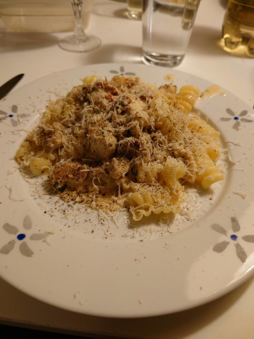 Pasta med kyckling, soltorkade tomater och riven parmesan, kryddat med svartpeppar.