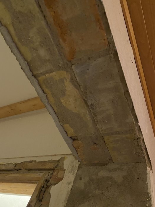 Tegelkonstruktion runt en dörröppning i ett gammalt hus, synliga tegelstenar och murbruk utan balk.
