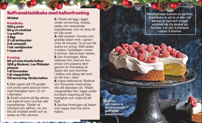 En saffranskladdkaka med hallonfrosting toppad med färska hallon på ett svart kakfat, omgiven av juldekorationer.