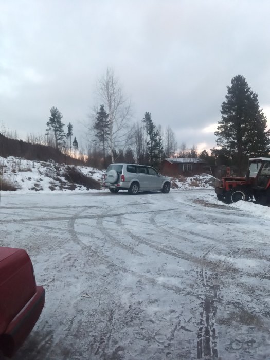 Bild på en ny bil parkerad utomhus, redo för besiktning, omgiven av snö och träd.