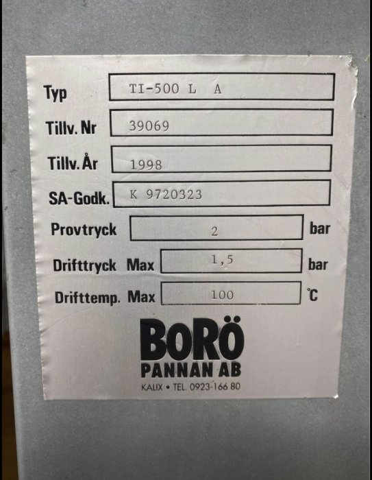 Informationsetikett för en 500-liters vattenmantlad kamin från BORÖ PANNAN AB, tillverkningsår 1998.