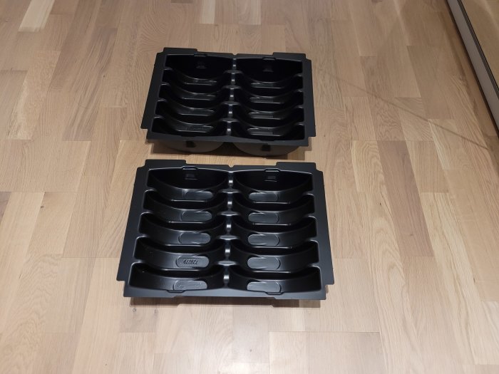 Två svarta insatser för 150 mm sliprondeller på trägolv.