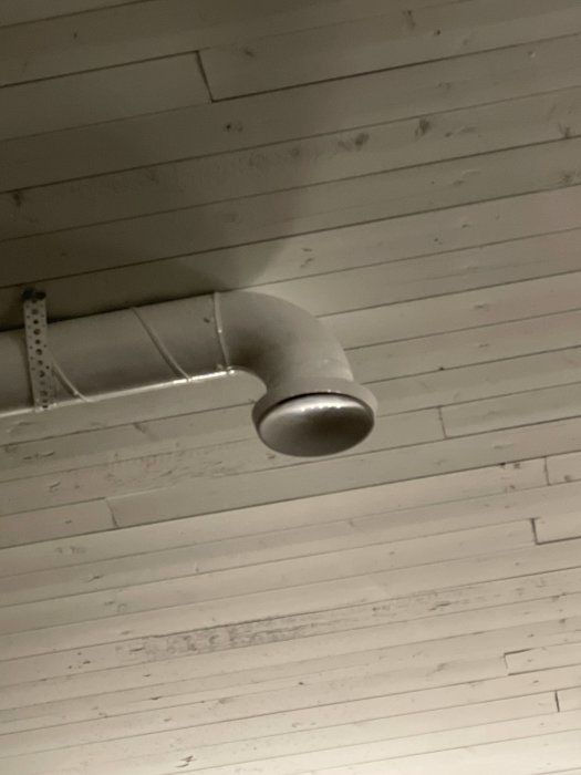 Tilluftsdon som sprider luft åt sidorna monterat på vitmålat tak.