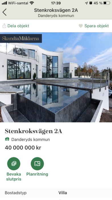 Modernt hus med stora fönster och arkitektoniska linjer samt reflekterande pool på uteplatsen.