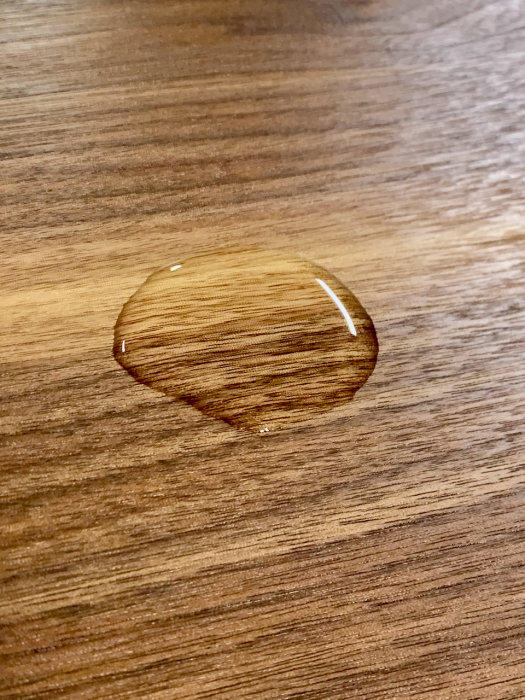 Vattendroppe på valnötskiva behandlad med fyra lager Danish skyddande finish.
