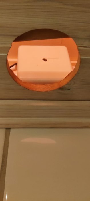 Elanslutning i taket ovanför kakel med synliga ledningar och dosa.