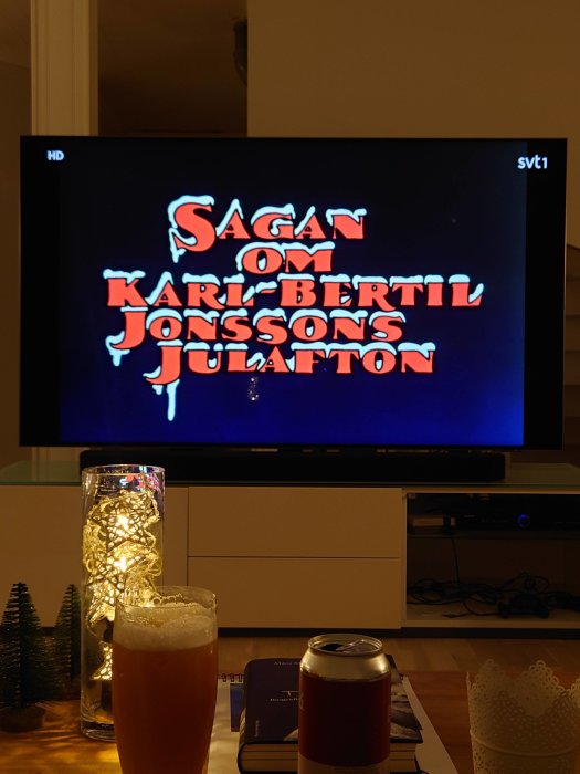 TV-skärm som visar titeln "Sagan om Karl-Bertil Jonssons julafton" med ett glas öl i förgrunden.