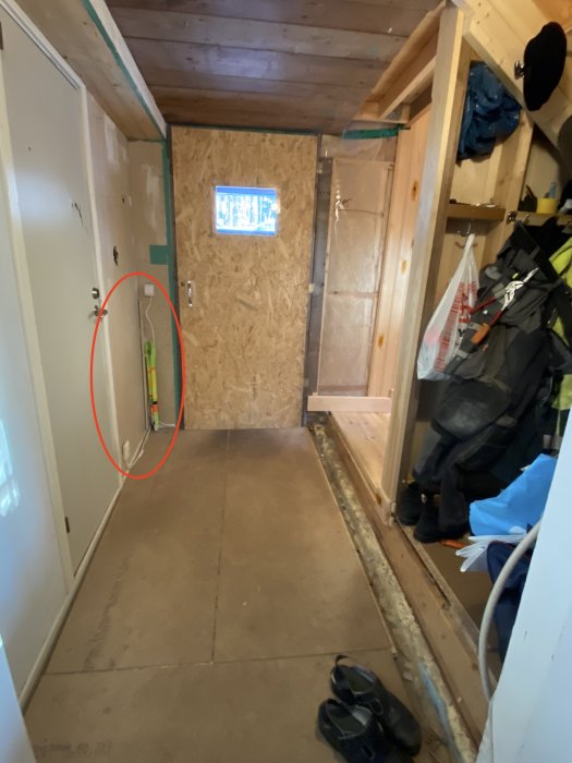 Hall under renovering med avslöjande av dåligt utförd eldragning längs en vägg.