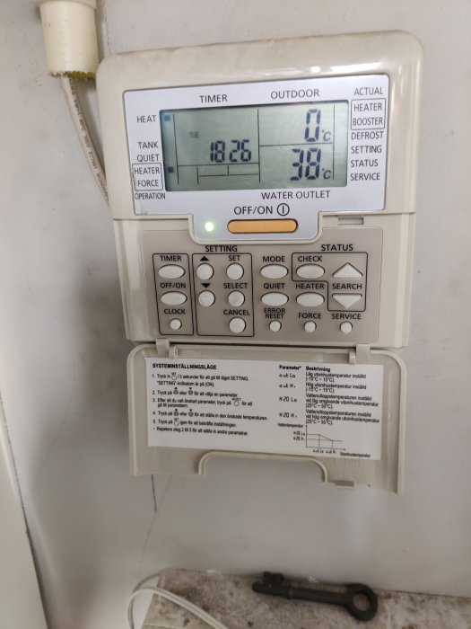 Värmesystemets kontrollpanel med felkoder och instruktioner, termometer visar 0°C utetemp och 30°C vattentemp.