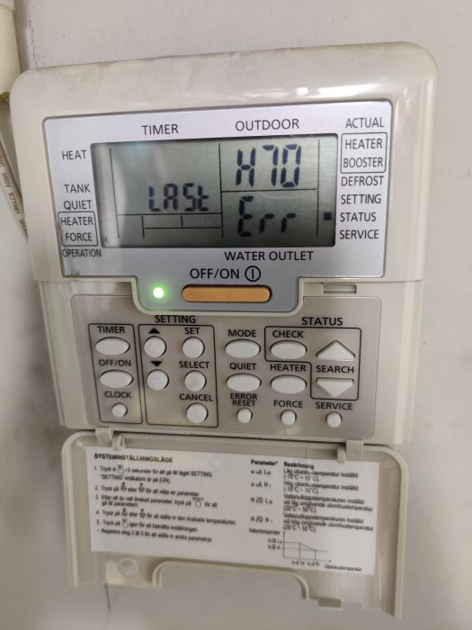 Värmepumpens kontrollpanel med felkod och instruktioner, visar temperaturer och inställningar.