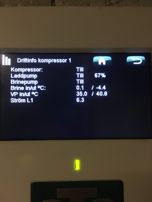 Displaypanel som visar driftinformation för värmepump med temperaturer och kompressoreffekt.