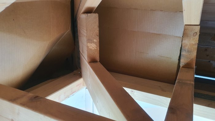 Takstol nära garageportöppning i byggprojekt, sett inifrån konstruktionen.
