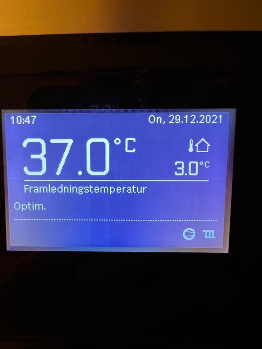 Display som visar framledningstemperatur på 37.0°C och utetemperatur på 3.0°C på värmepumpens kontrollpanel.