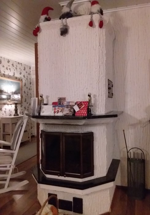 Eldstad med cementblock och ojämn, cementbaserad yta som liknar en pizzeriavägg, dekorerad med julsaker.