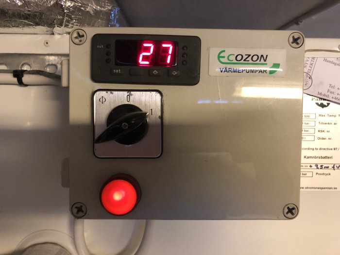 Panel av en Ecozon värmepump med röd lysande lampa och digital display som visar 27.