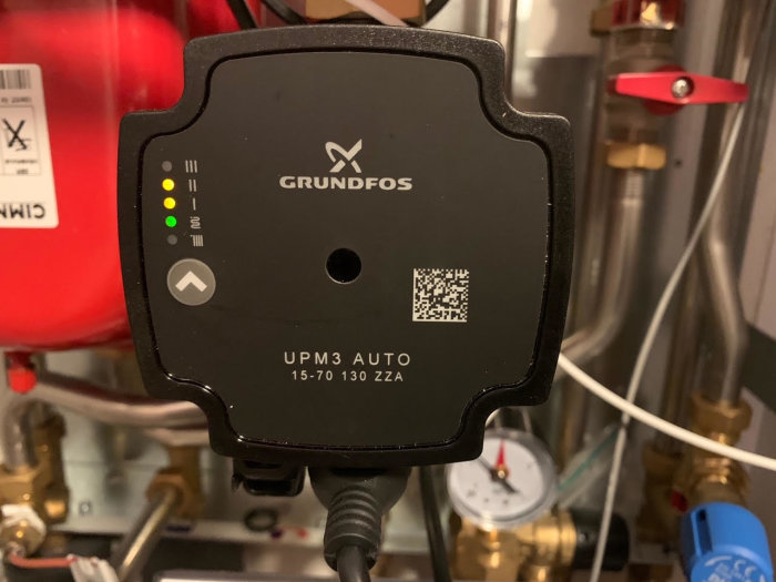 Närbild av en Grundfos UPM3 AUTO cirkulationspump i en fjärrvärmecentral.