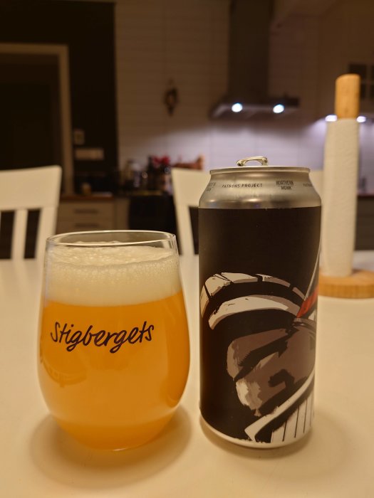 Ett glas med Neipa-öl bredvid en Northern Monk burk på ett köksbord.