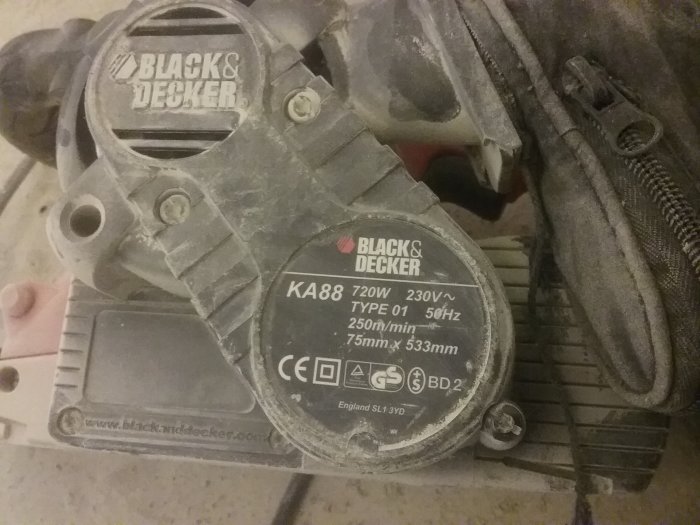 Använd och dammig Black & Decker bandslipmaskin modell KA88 på ett golv.