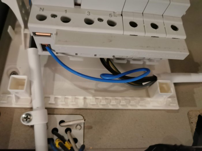 Elektrisk installation med färgordningsfel på kablar och skalning över fasskena i ett fasadskåp.