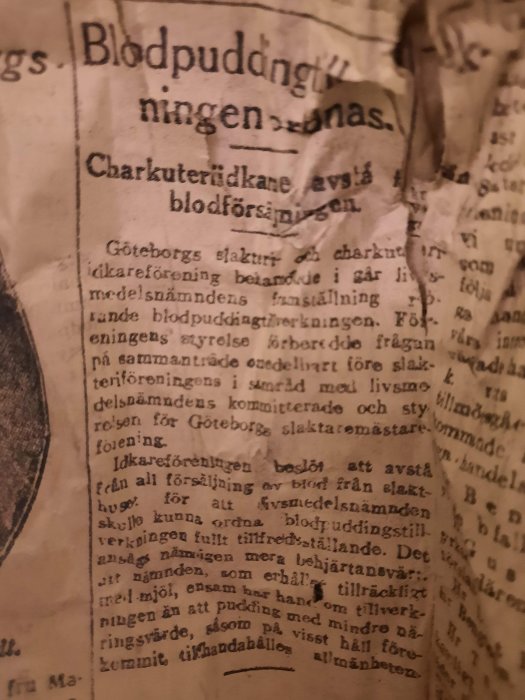 Nött tidningspapper från 1918 med text om blodpuddingstillverkning och Göteborgs slakthusförening.