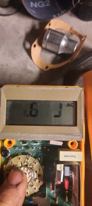 En gammal Fluke 23 multimeter med svårtydd skärm, demonterad och hållen i en hand.