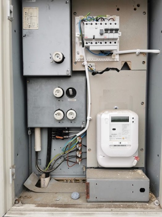 Elskåp öppet visar installation av uttag, jordfelsbrytare, och skarvade kablar.