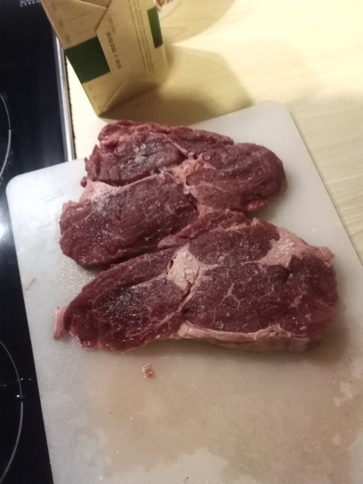 Entrecote-skivor skurna i 2.5 cm tjocklek på en skärbräda.