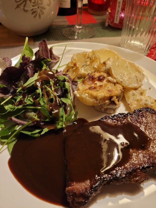 Ryggbiff med rödvinssås och potatisgratäng, sallad på sidan, festmåltid för nyår.