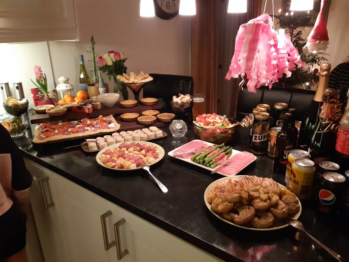 Buffébord med varierade rätter inklusive smörgåstårta, kallskuret och pajer, dekorerat med blommor och juldekorationer.