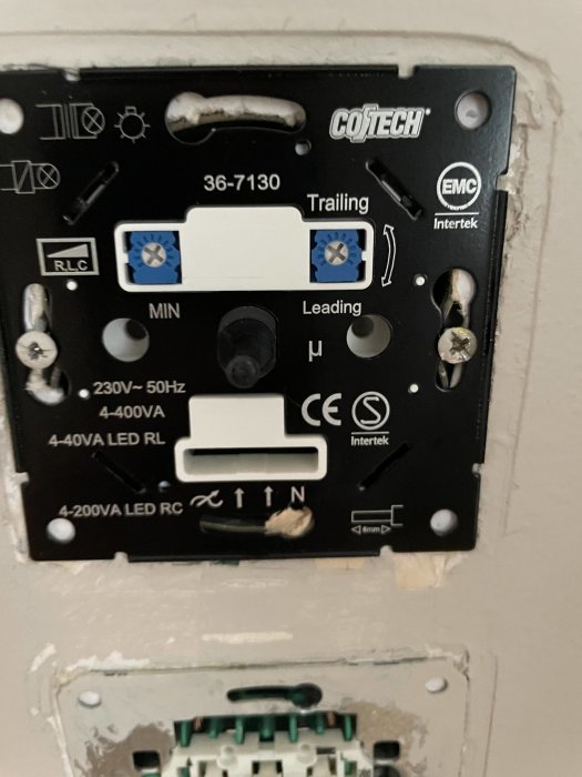 Dimmer från Cotech monterad i vägg utan frontplatta, synliga ledningar och skruvanslutningar.