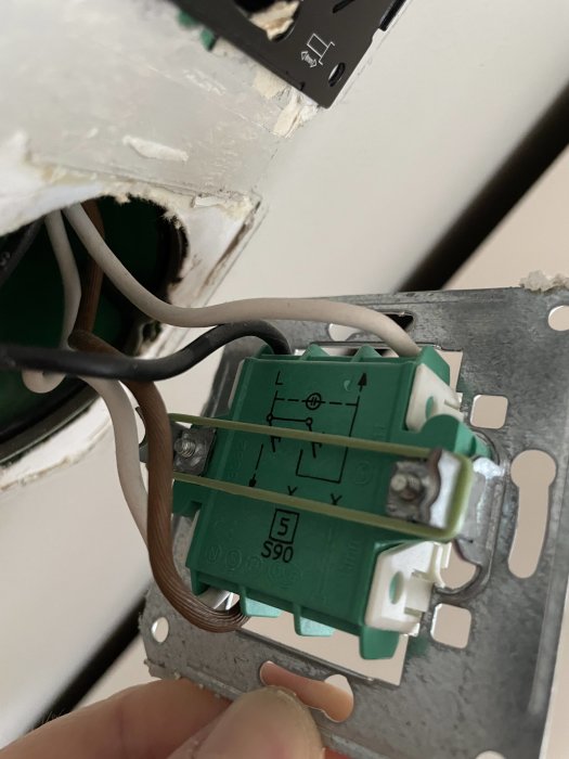 En nyinstallerad dimmer från Cotech med anslutna eltrådar synlig i öppet eluttag.