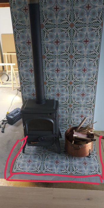 Kakelugn på mönstrat kakel med parkettgolv och markerad sågad ram.