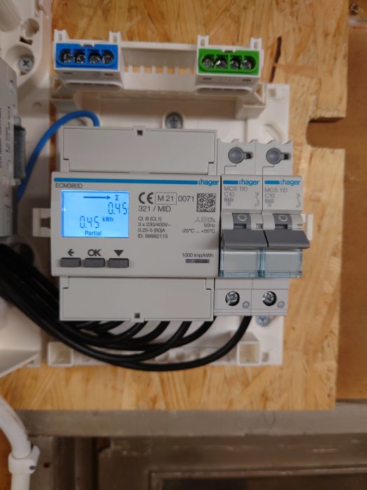 Elmätare installerad i en snickarbod med en display som visar 0.045 kWh förbrukning.