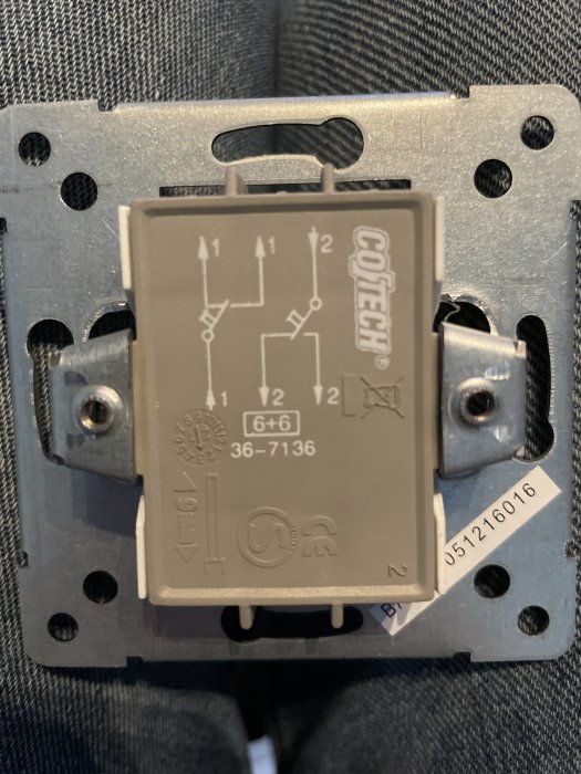 Eluttag för en dubbeltrappströmbrytare, märkt med "6+6" och elschema, monterat på en väggplatta.