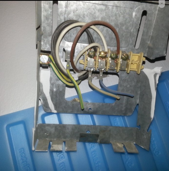 Elektriska kablar i kopplingsbox med bruna, svarta, blåa och gul/gröna ledare samt öppet verktygslåda.